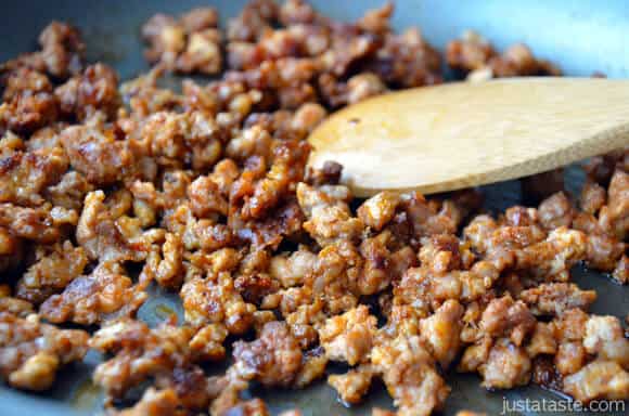 Browned, crumbled chorizo being cooked in a skillet.