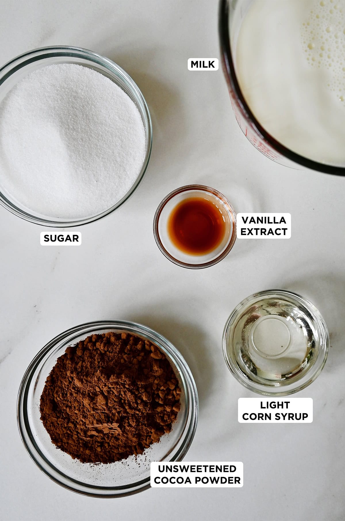 The six ingredients needed to make fudge pops: sugar, milk, light corn syrup, vanilla extract and cocoa powder.