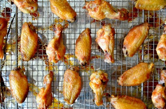 Baked chicken wings on wire rack.