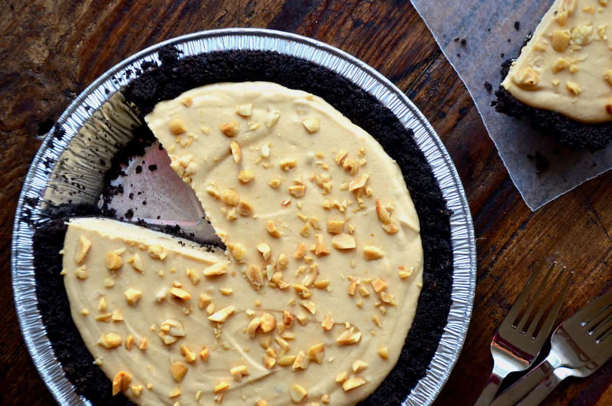 Frozen peanut butter banana pie with a chocolate cookie crust topped with chopped peanuts. 