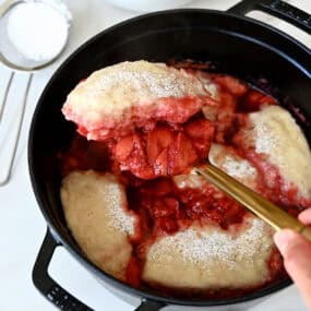 Stovetop strawberry dumplings in a saucepan.