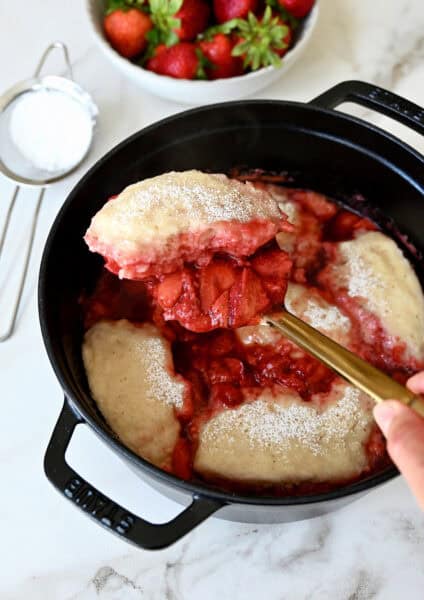 Stovetop strawberry dumplings in a saucepan.