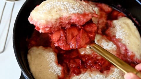 Stovetop strawberry dumplings in a saucepan.