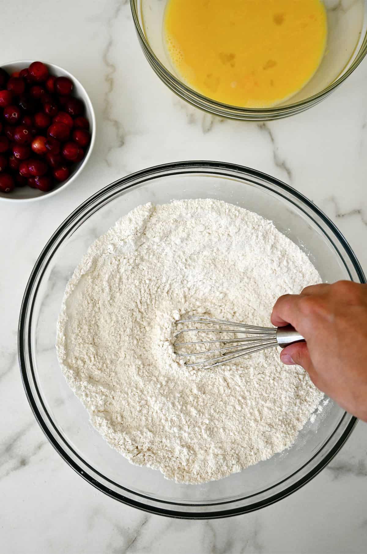 Dry ingredients for cranberry bread in a large glass bowl.