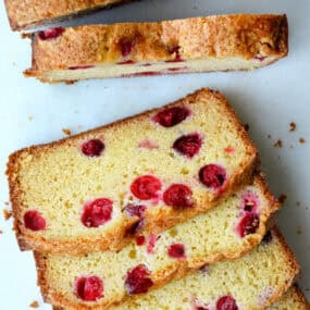 A loaf of cranberry orange bread cut into slices.