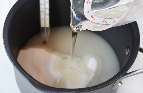 Saucepan containing sugar and corn syrup with candy thermometer