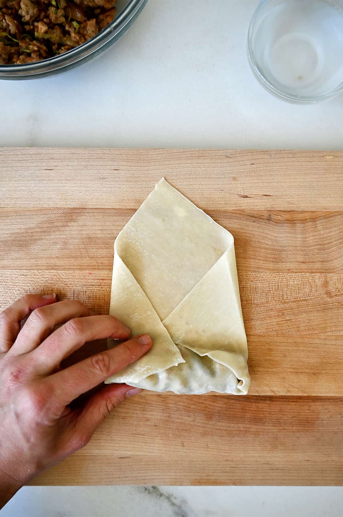 Step 3 in assembling a spring roll: Folding in the sides before rolling. 