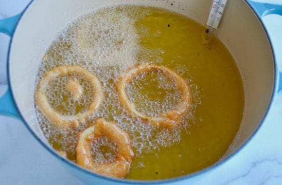 A Dutch oven filled with oil and onions frying