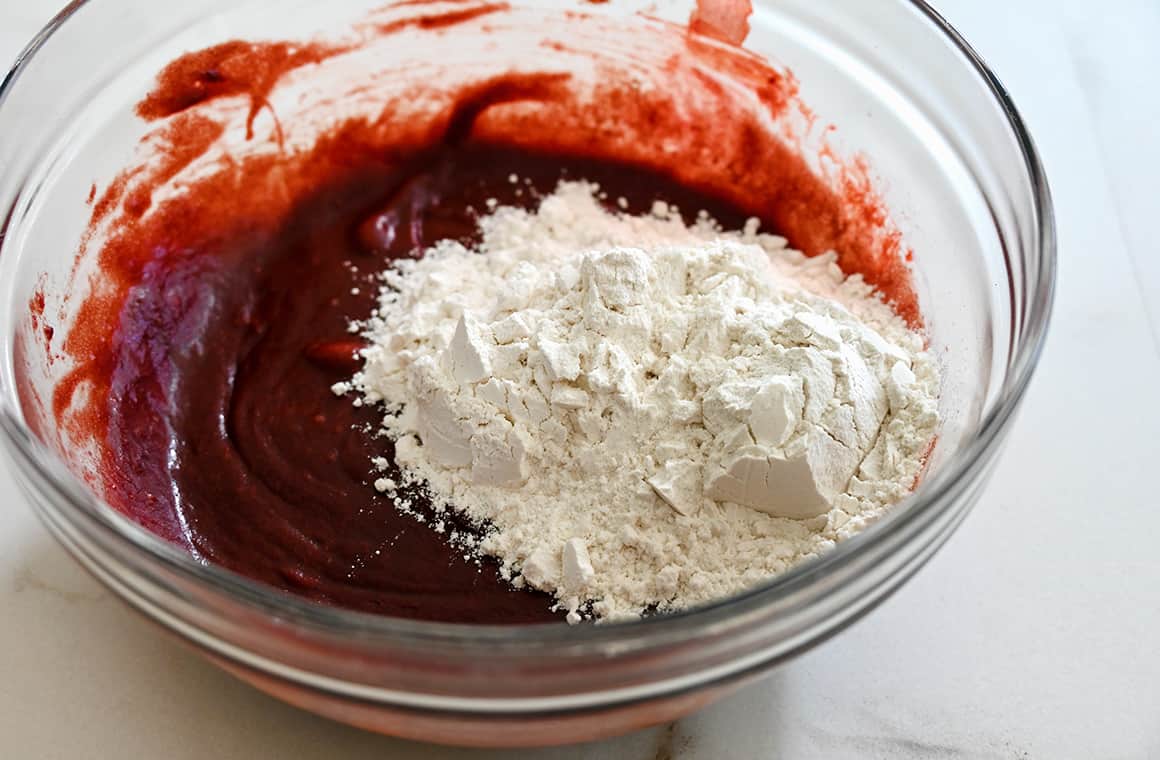 A clear bowl containing red velvet brownie batter