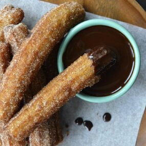 Top down view of easy homemade churros dunked in chocolate sauce