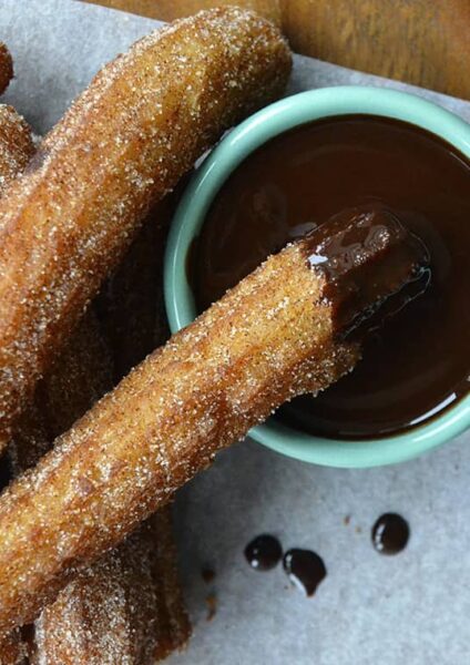 Top down view of easy homemade churros dunked in chocolate sauce