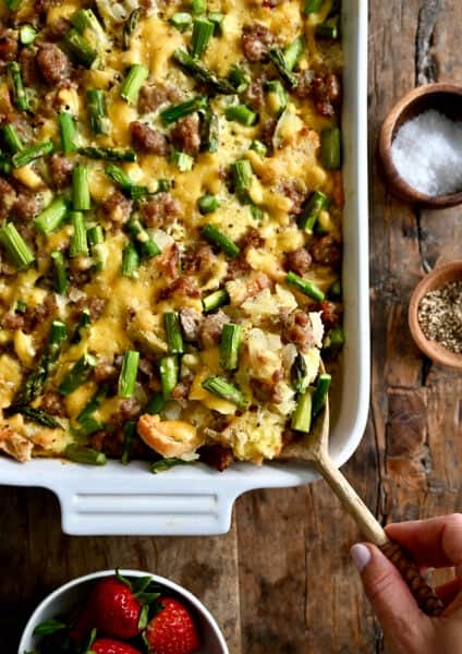 Overnight breakfast strata with sausage and asparagus in a 9x13 baking dish.