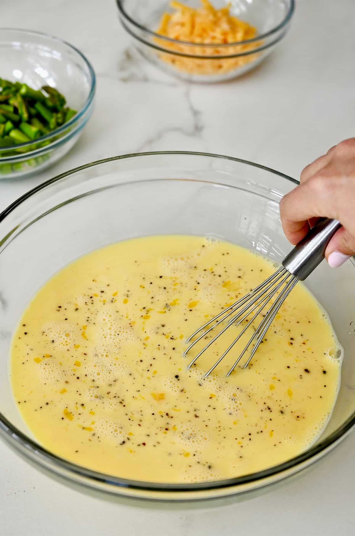 Whisked eggs with Dijon mustard, milk, salt and pepper in a large bowl.