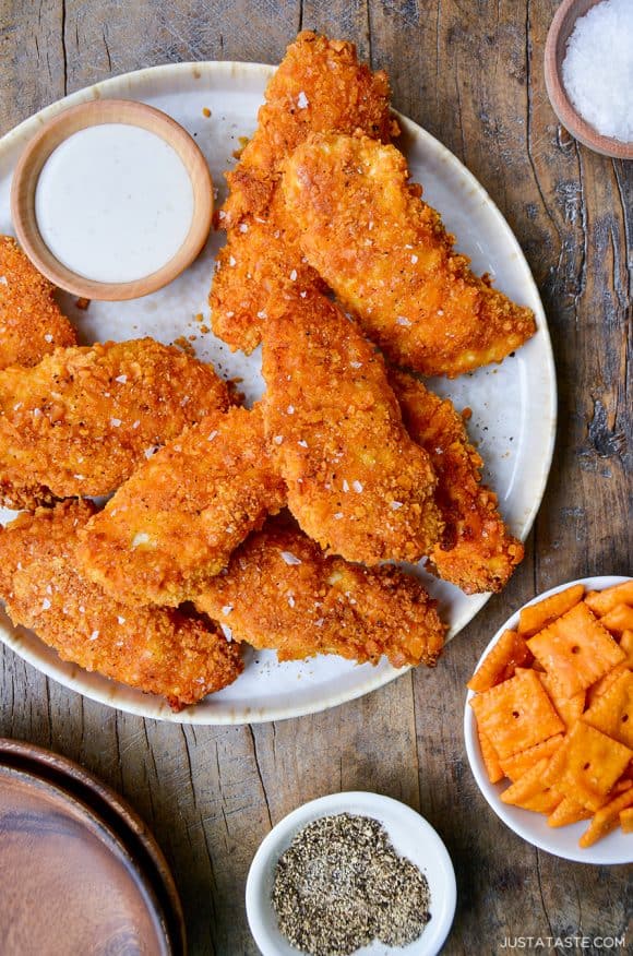 Crispy Baked Cheddar-Dijon Chicken Tenders on a white plate next to a small ramekin with ranch