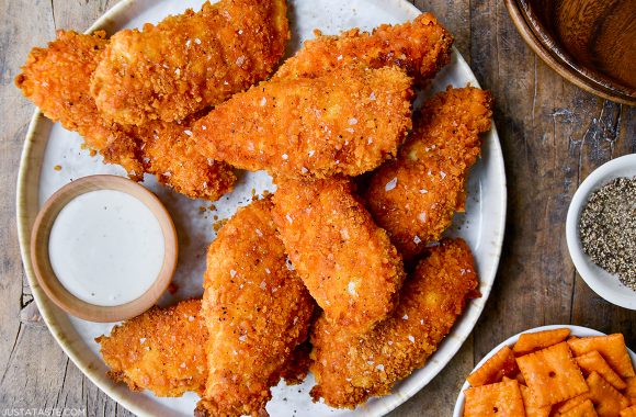 30-Minute Baked Cheddar-Dijon Chicken Tenders on dinner plate next to small ramekin with ranch
