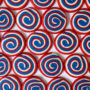 A top-down view of multiple rows of July 4th pinwheel cookies.