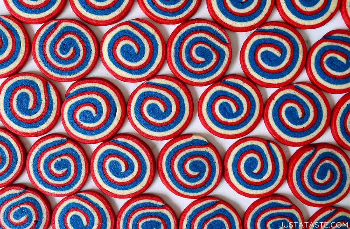A top-down view of multiple rows of July 4th pinwheel cookies.