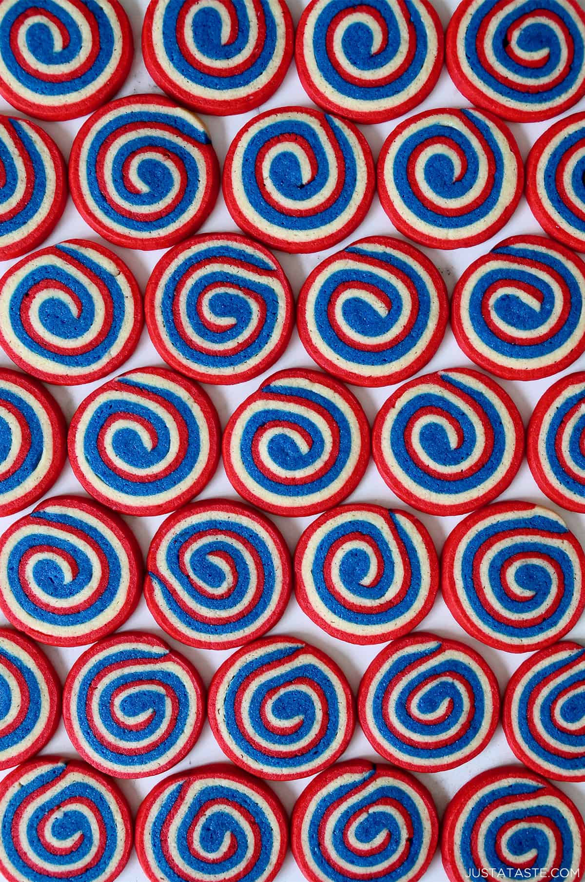 A top-down view of rows of red, white and blue pinwheel icebox cookies.