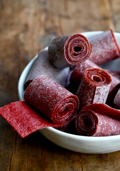 Homemade strawberry fruit roll-ups in a white bowl.