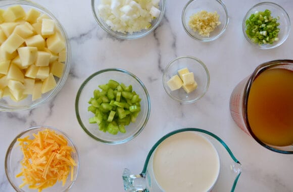 Various sizes of bowls containing potato soup ingredients