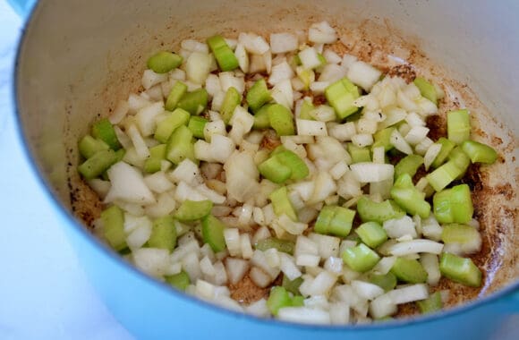 Large stockpot containing sautéed vegetables