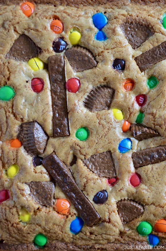 Closeup view of Leftover Halloween Candy Blondies studded with Reese's Peanut Butter Cups, M&M's and Kit Kat Bars