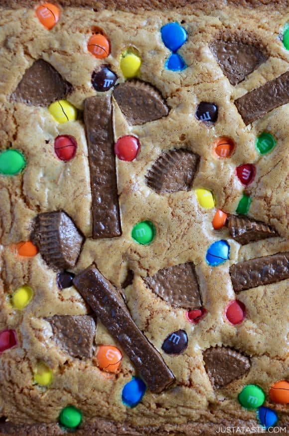 Closeup view of Leftover Halloween Candy Blondies studded with Reese's Peanut Butter Cups, M&M's and Kit Kat Bars