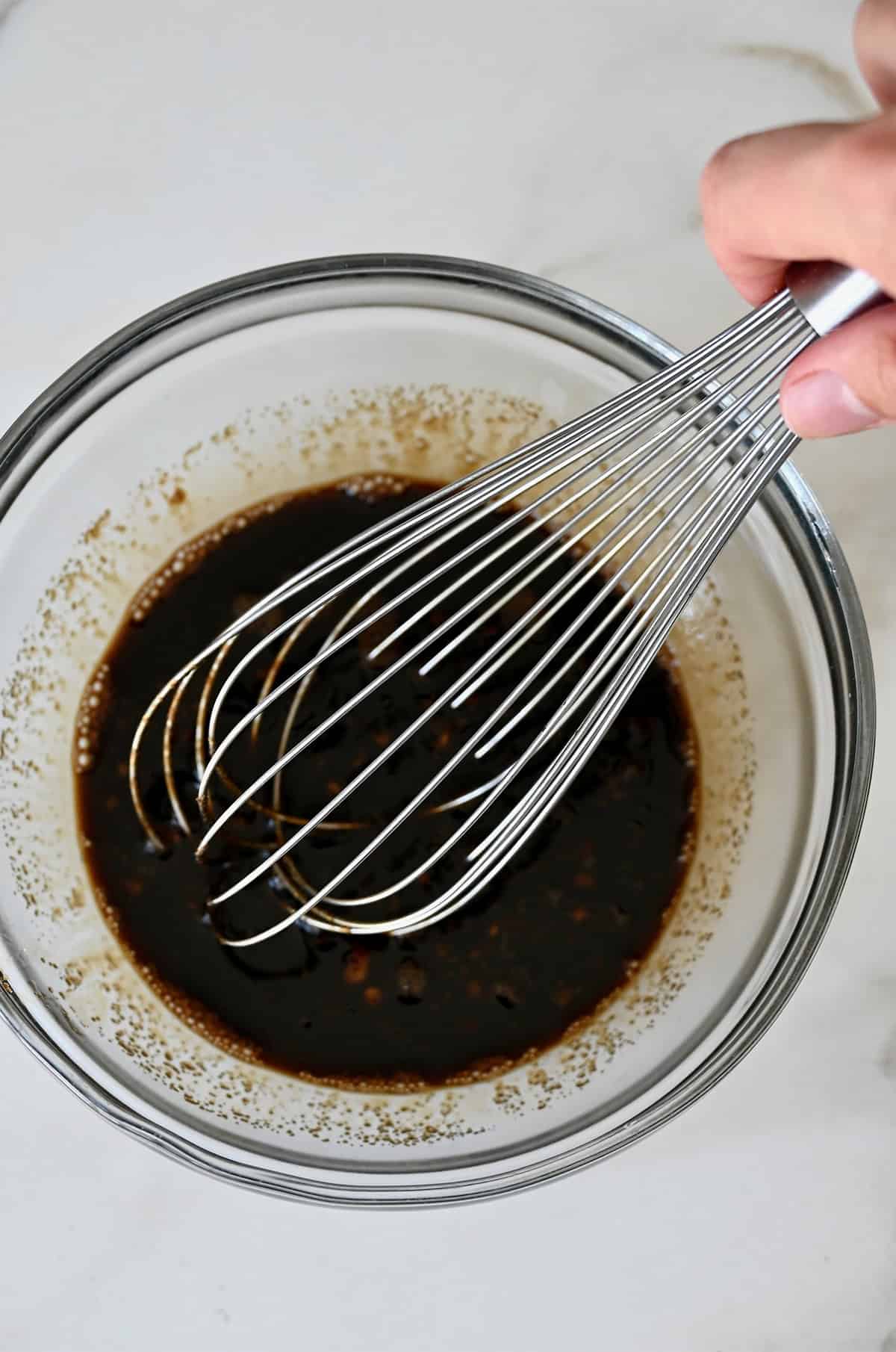 Pad Thai sauce in a bowl with a wire whisk.