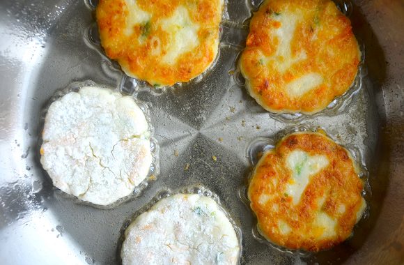 A frying pan containing potato pancakes