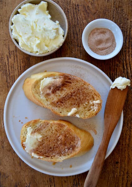 A top-down view of slices of cinnamon-sugar toast with a small bowl of butter