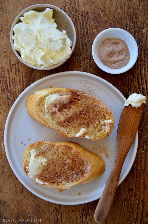 A top-down view of slices of cinnamon-sugar toast with a small bowl of butter