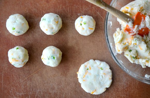 Mashed potato balls being formed into pancakes