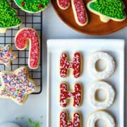 A top-down view of Cutout Christmas Sugar cookies decorated with frosting and sprinkles