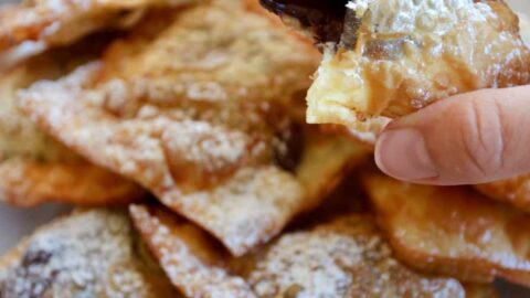 A close-up shot of a chocolate wonton with a bite taken out of it