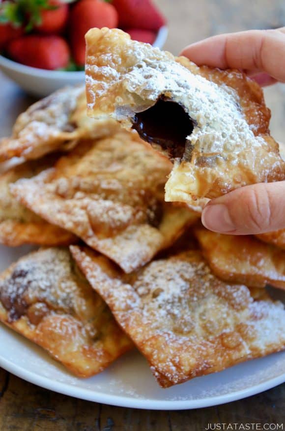 A close-up shot of a chocolate wonton with a bite taken out of it