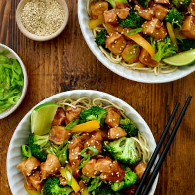 A top-down view of two bowls containing 30-Minute Chicken and Broccoli Stir-Fry and chopsticks