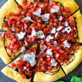 Bruschetta pizza with balsamic syrup and shaved Parmesan cheese.