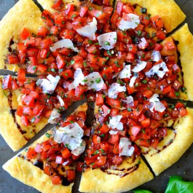 Bruschetta pizza with balsamic syrup and shaved Parmesan cheese.
