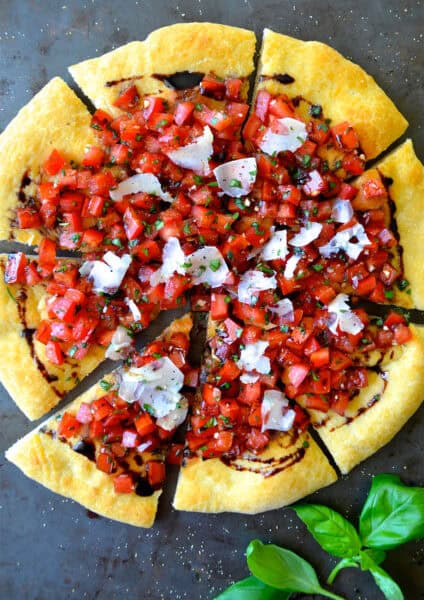Bruschetta pizza with balsamic syrup and shaved Parmesan cheese.