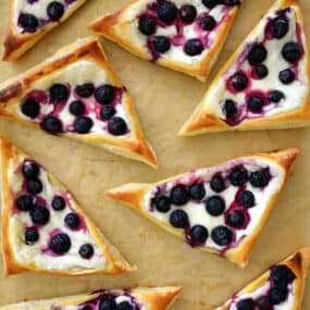 Top-down view of Blueberry Cream Cheese Pastries on brown parchment paper.