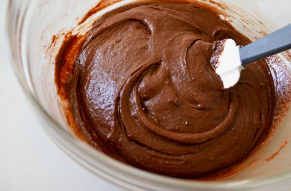 Brownie batter in clear bowl with spatula