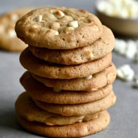 A tall stack of white chocolate chip cheesecake cookies.