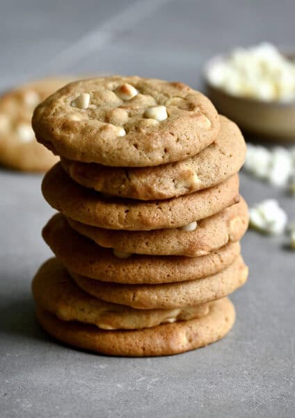A tall stack of white chocolate chip cheesecake cookies.