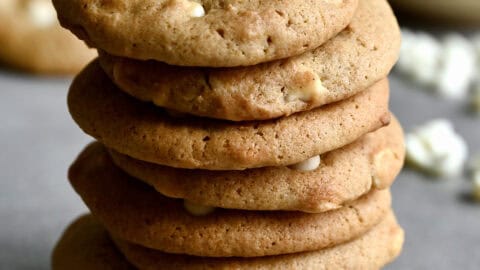 A tall stack of white chocolate chip cheesecake cookies.
