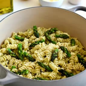 A large stockpot containing Cheesy Asparagus Pesto Pasta with fresh asparagus pieces