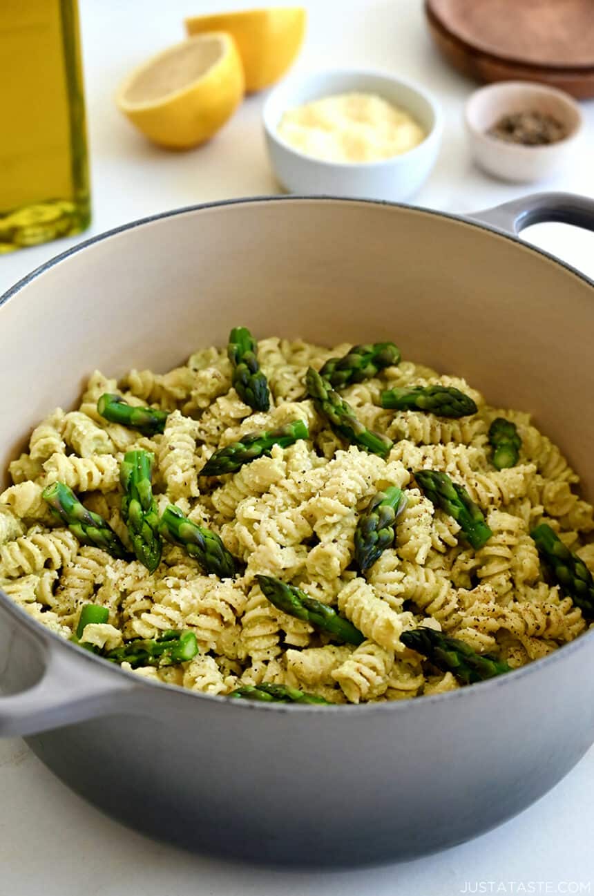 A large stockpot containing Cheesy Asparagus Pesto Pasta with fresh asparagus pieces