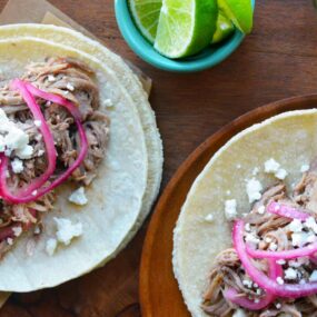Slow Cooker Pulled Pork Tacos topped with pickled red onions