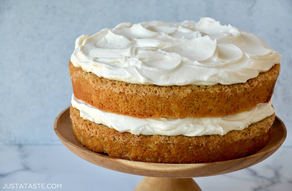 The Best Banana Cake with Cream Cheese Frosting on a wooden cake stand