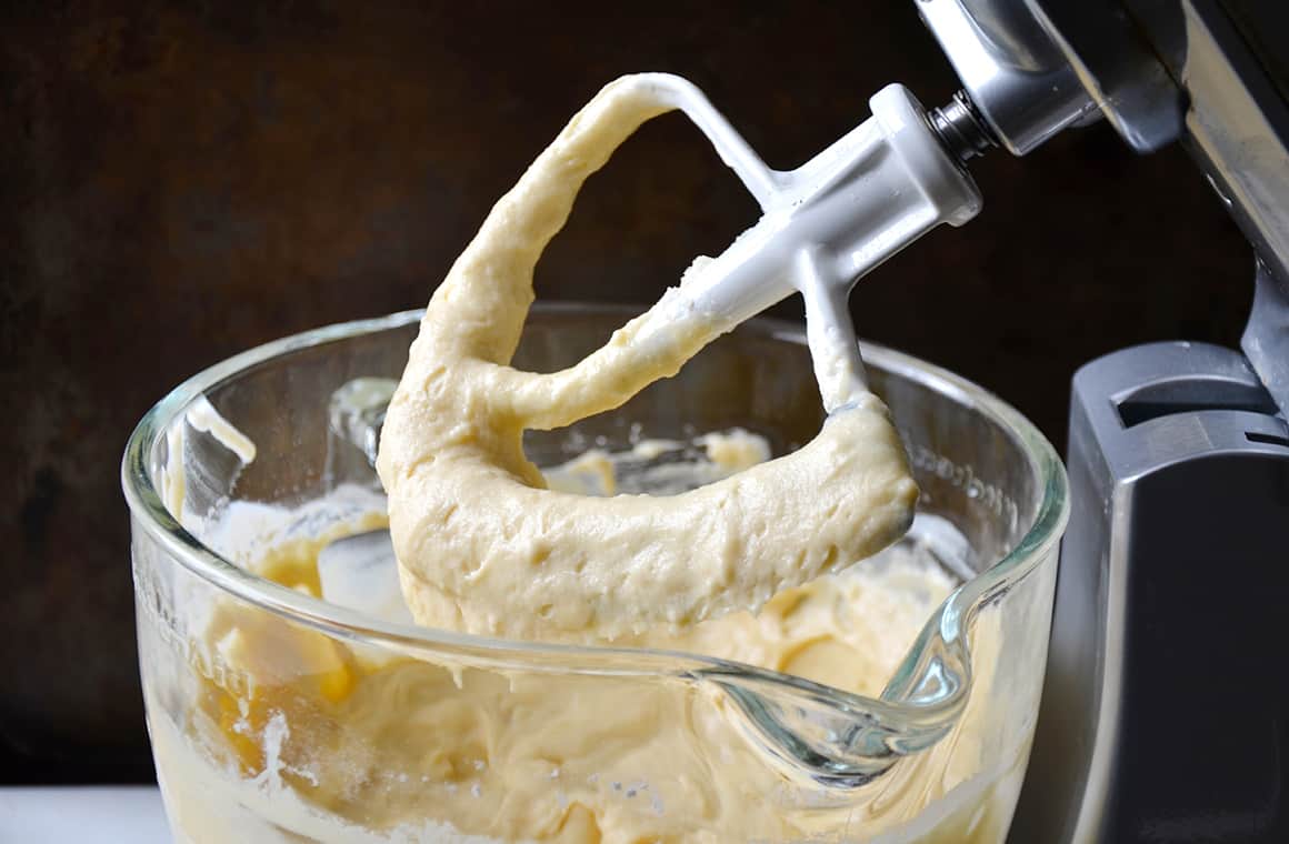 Stand mixer paddle attachment over glass bowl with batter