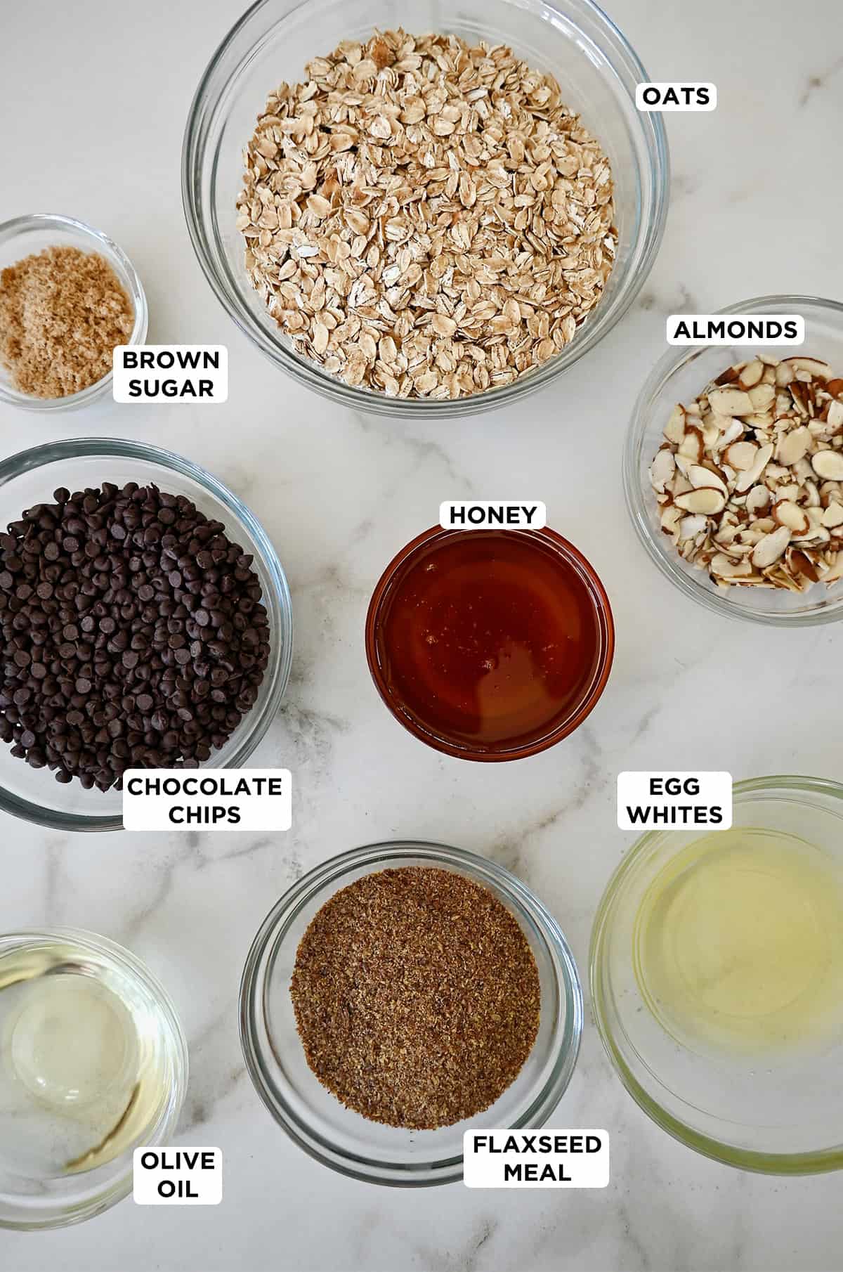 Homemade granola bar ingrredients in various sizes of prep bowls.